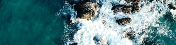 Image of the sea crashing into rocks.